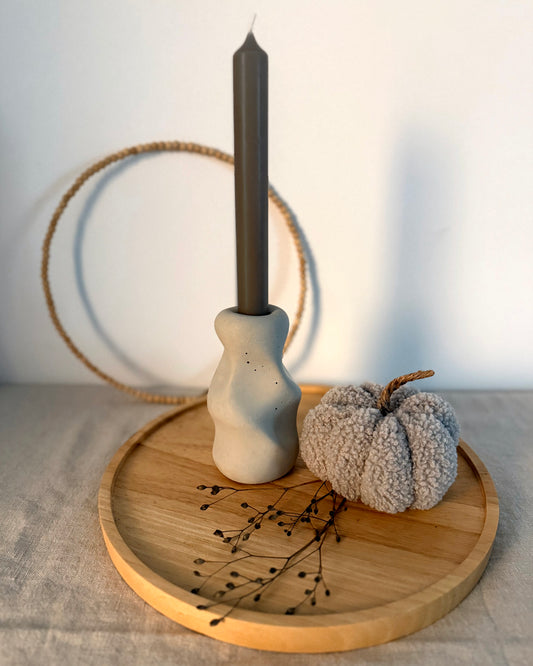 Kerzenständer Organic mit dunkler Stabkerze auf Holztablett neben einem Stoffkürbis