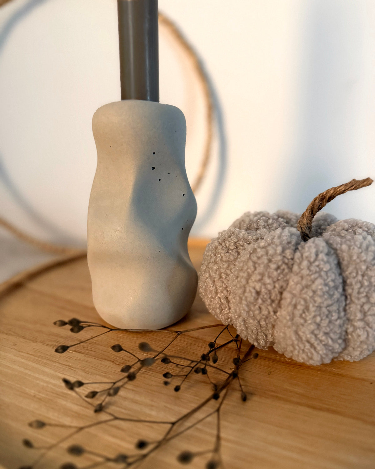 Nahaufnahme des Kerzenständers Organic mit sichtbaren Poren und dunkler Stabkerze